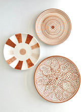 Load image into Gallery viewer, Terracotta color Moroccan zwak design handmade hand painted ceramic plate on a table with two matching plates
